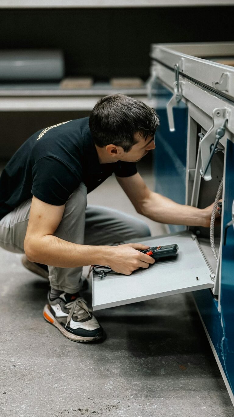 A focused technician inspects machinery indoors, ensuring operational efficiency.